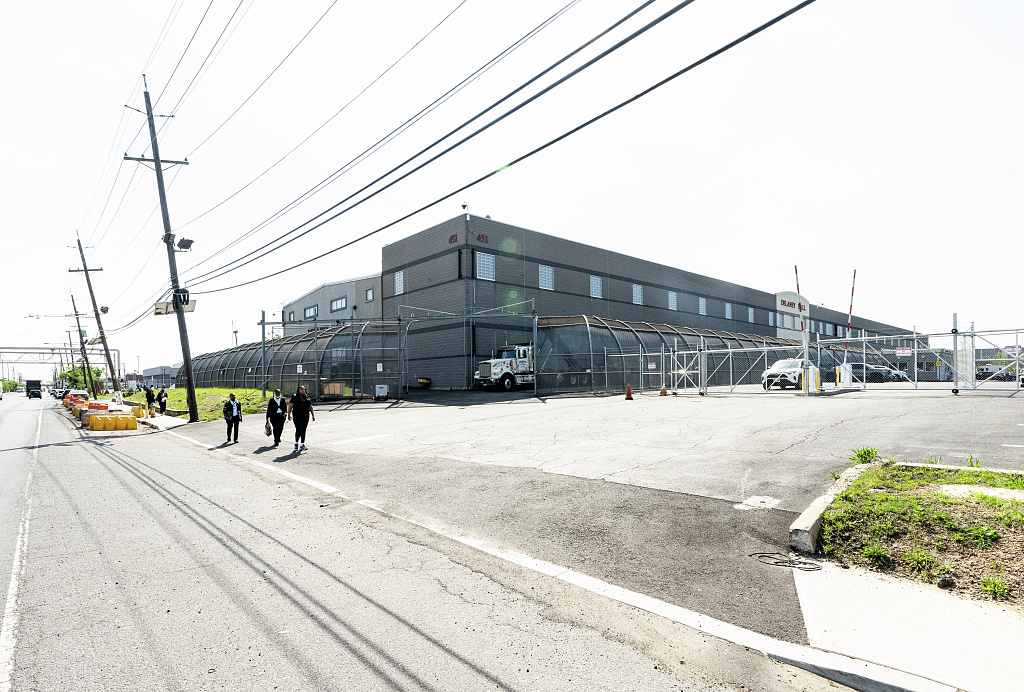 Exterior of a large immigration detention facility with security fencing